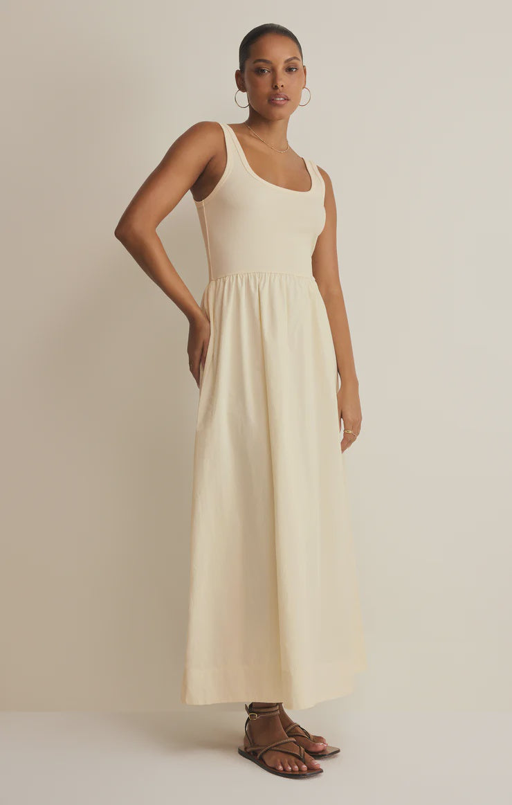 Woman wearing an off white sleeveless poplin dress against a plain background