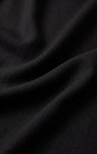 Close-up of the Z Supply Leyla Jumpsuit's black fabric, showing its soft, lightweight rayon-spandex blend with a smooth texture and fluid drape.