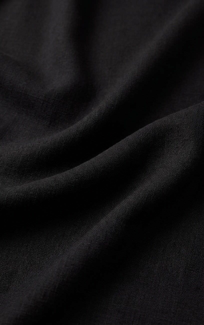 Close-up of the Z Supply Leyla Jumpsuit's black fabric, showing its soft, lightweight rayon-spandex blend with a smooth texture and fluid drape.