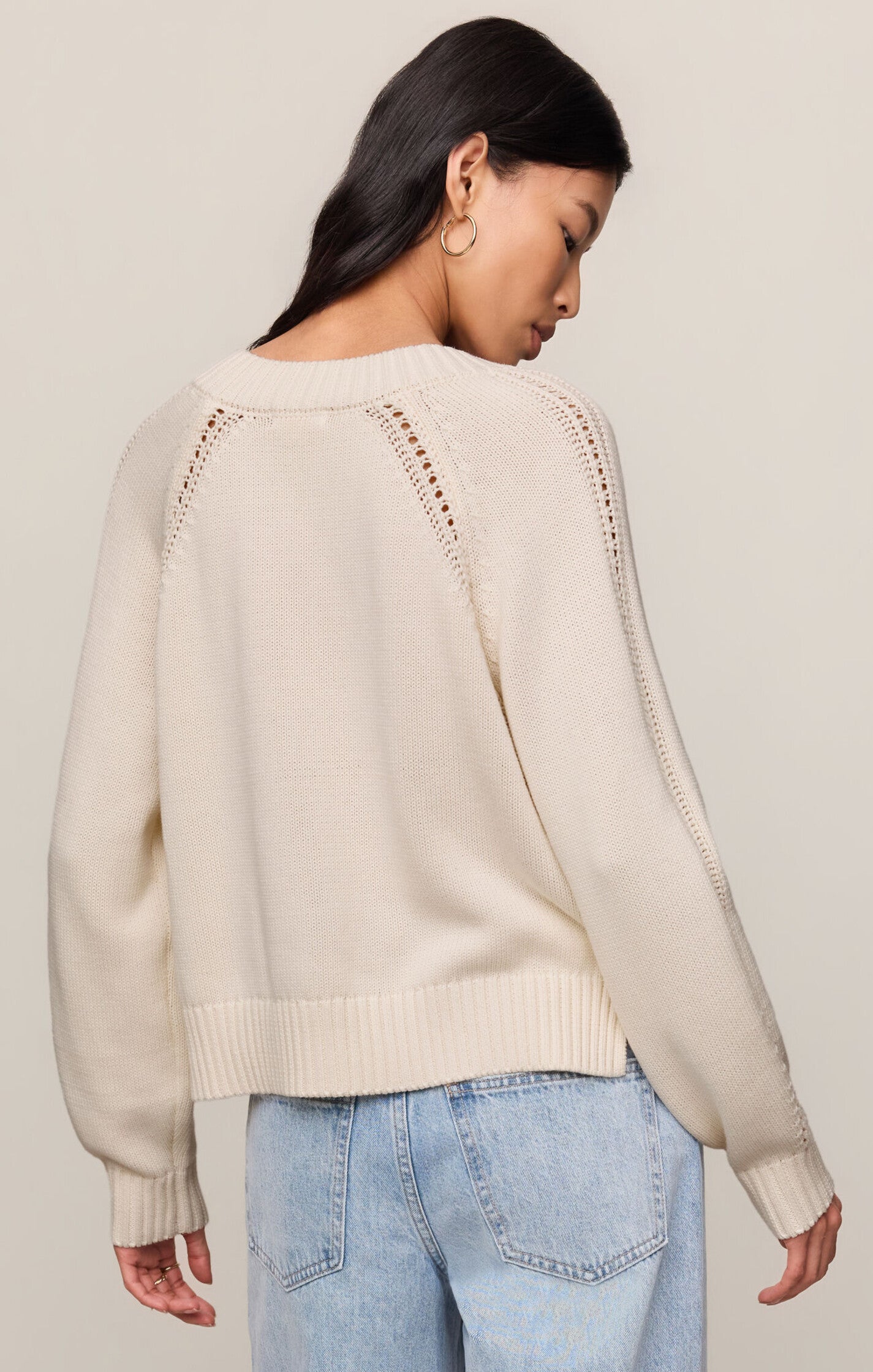 Model wearing the Z Supply Stratton V-Neck Sweater in Sandstone, featuring a V-neckline, long sleeves, and a soft cotton knit in a neutral beige hue.