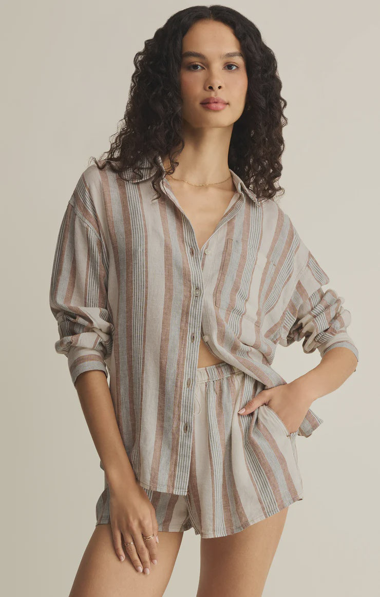 Woman wearing a striped shirt and shorts set on a beige background