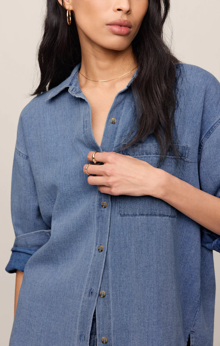 Relaxed-fit indigo cotton twill button-up shirt with a collared neckline, long sleeves, button-front closure, and a single chest pocket. Made from 100% cotton with a soft, drapey feel.