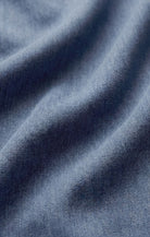 Close-up of soft indigo cotton twill fabric, showcasing its smooth texture, subtle diagonal weave, and lightweight construction with a naturally relaxed drape.