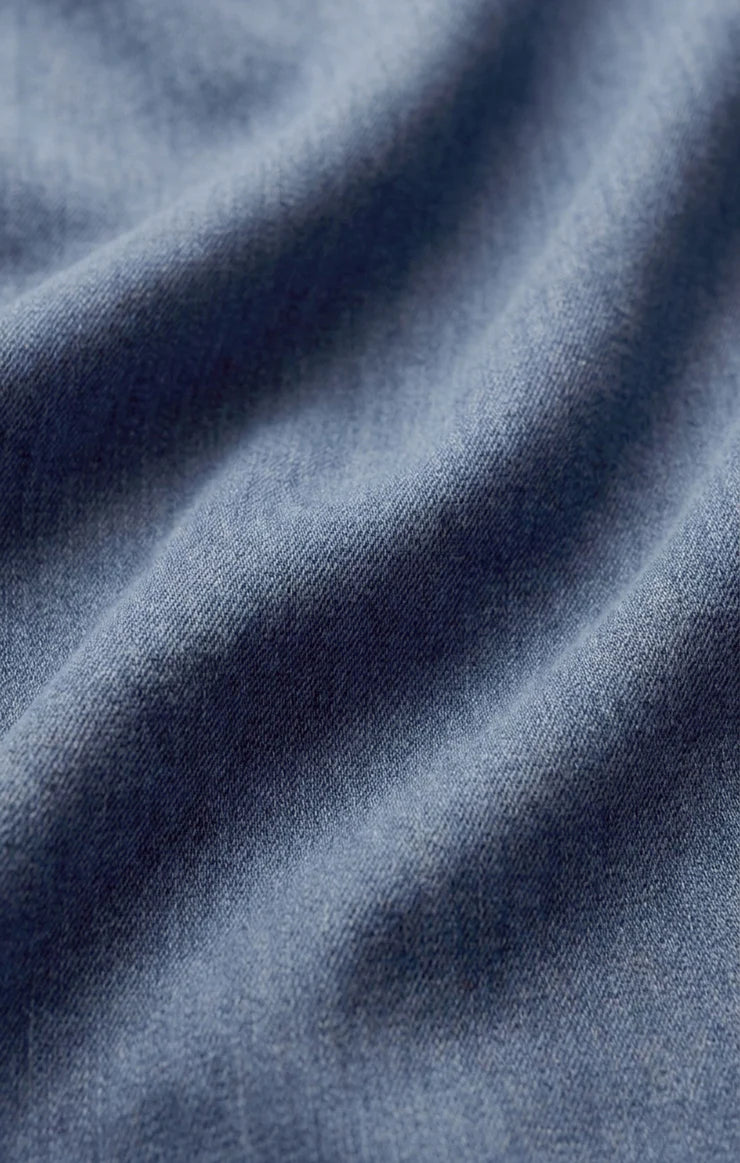 Close-up of soft indigo cotton twill fabric, showcasing its smooth texture, subtle diagonal weave, and lightweight construction with a naturally relaxed drape.
